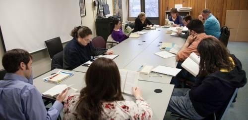 English graduate students reading and working around a large table together