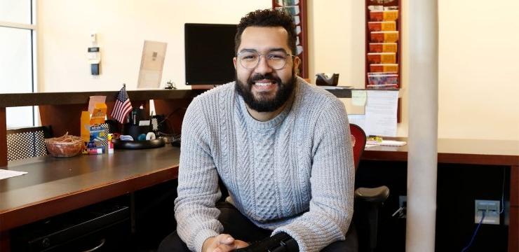 Steven Pina leans forward in chair and smiles